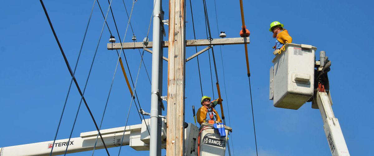 Workers using a lift to repair a utility line