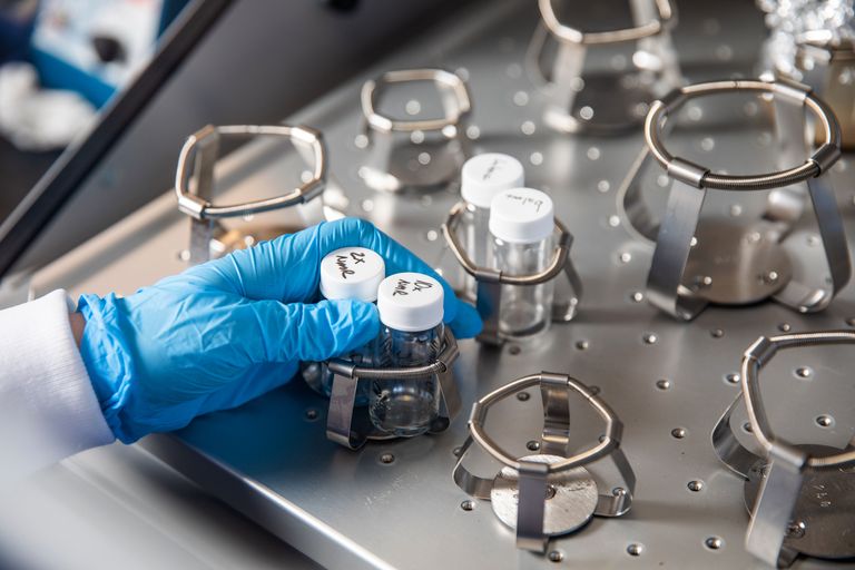 Gloved hand conducting research on polymeric nanoparticles