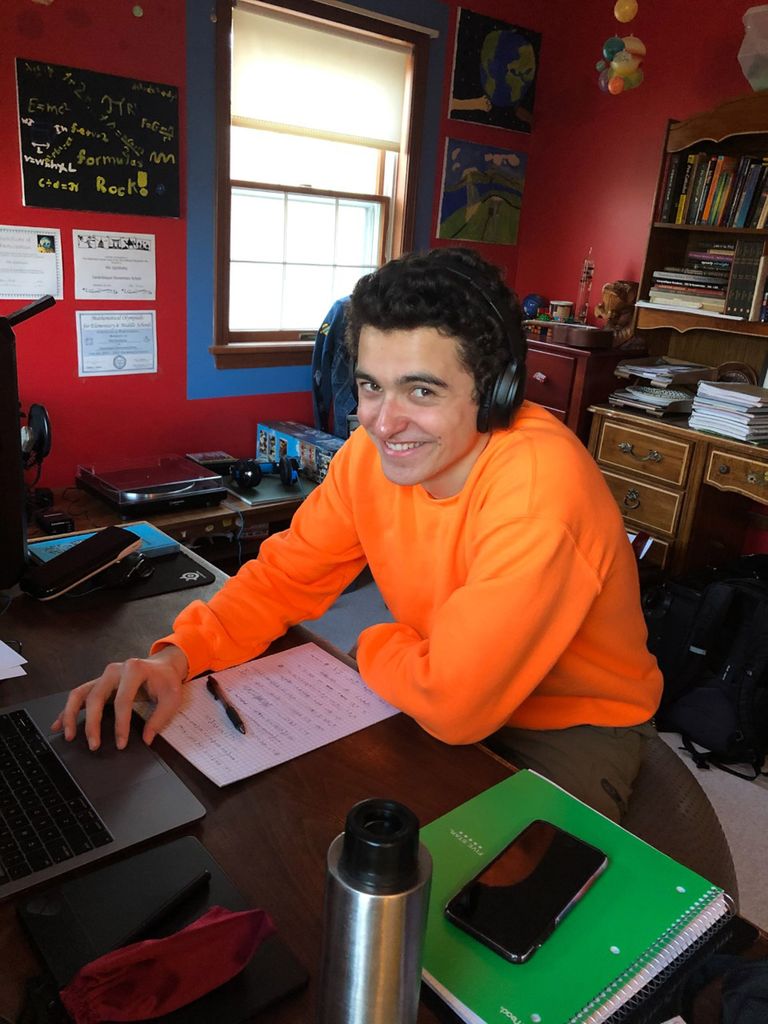 A photo of Nik Gjonbalai working at his computer at home