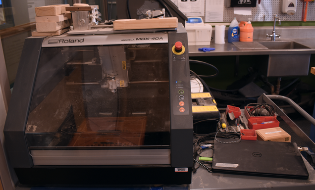 Desktop CNC machine in SILab with the computer that controls it next to it