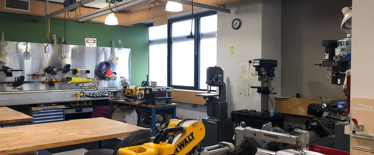 view of the shop space in SILab; there is a variety of wood/metal working lining the back right of the image and hand tools along the back left