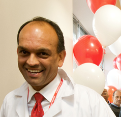 Binoy K Singh, an Indian man wearing a doctor's lab coat and a red tie, in front of red and white balloons