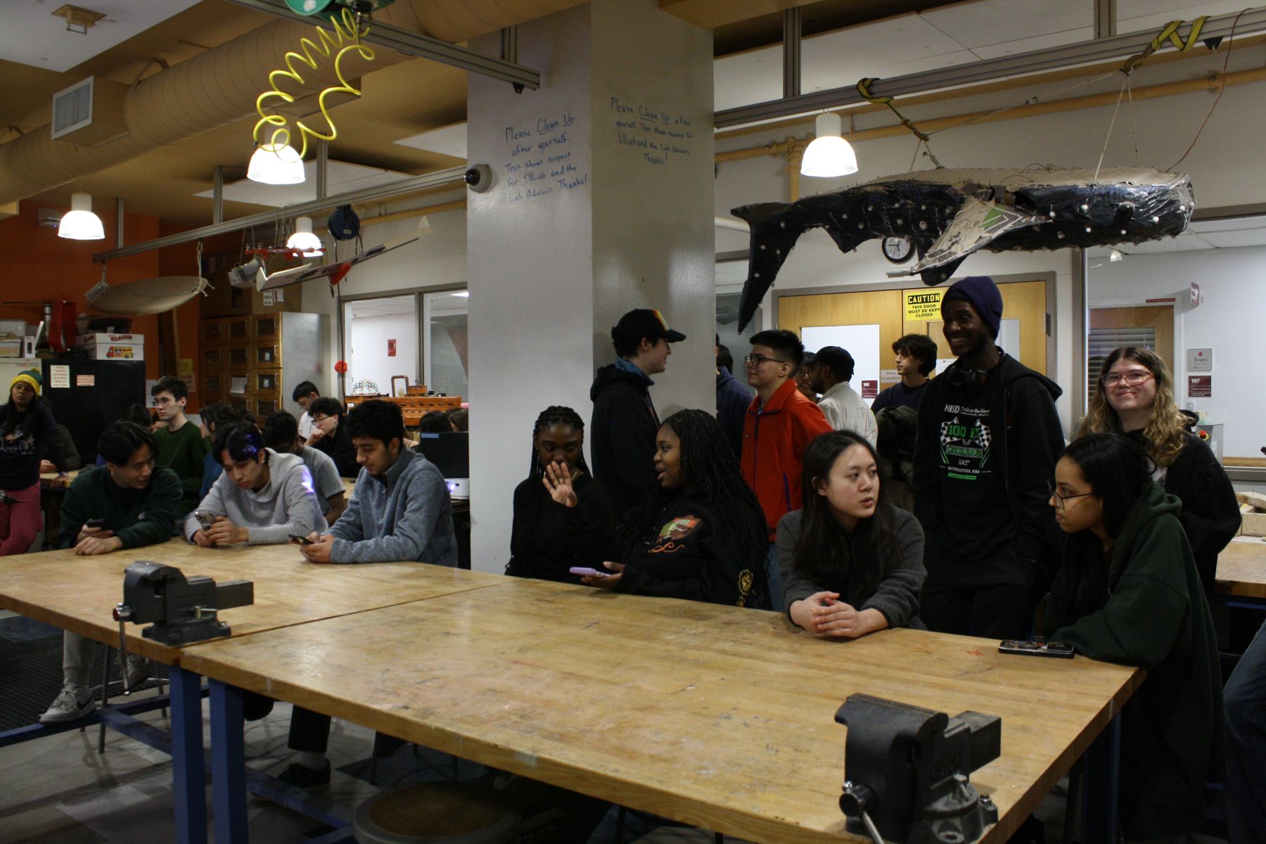 large group of students clustered around long tables in SILab