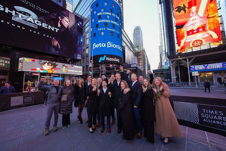 people in front of NASDAQ stock market