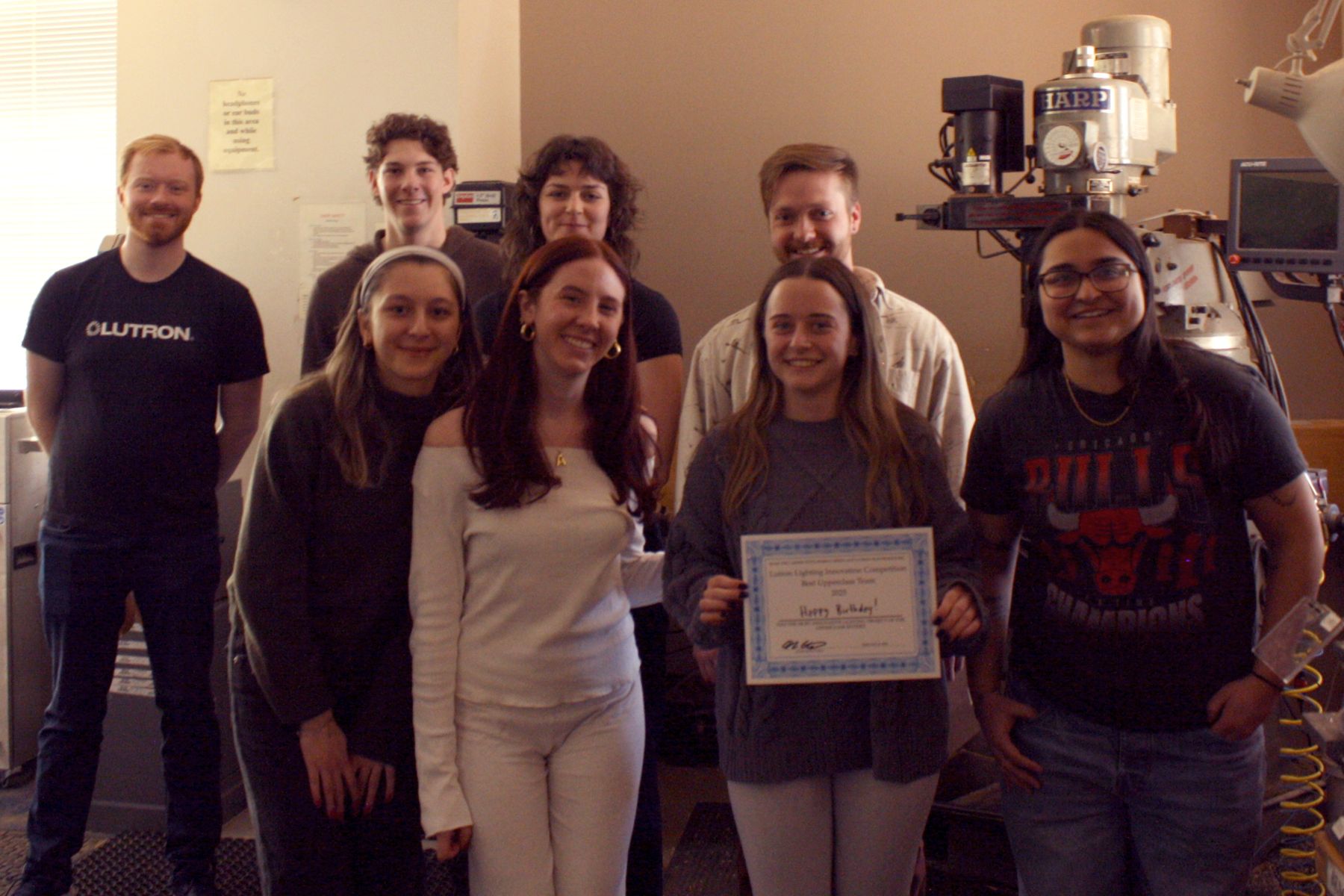 4 students who made the birthday cake pictured with the Lutron judges and holding a Best Upper Class Project certificate