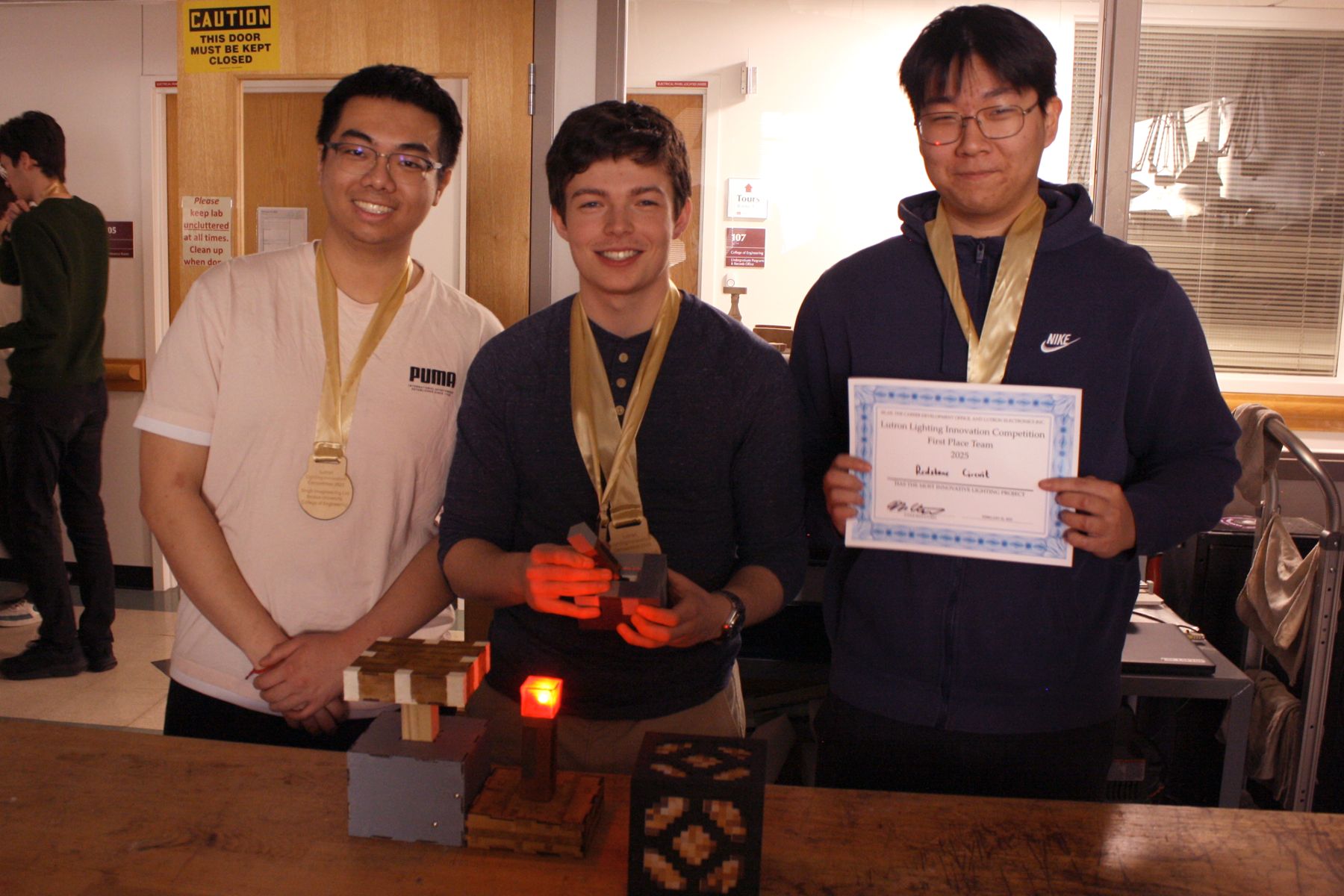 3 of the students from the minecraft team with their project and 1st place medals