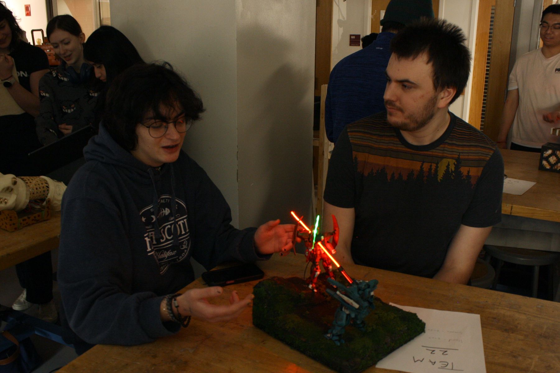 2 students showing off their diorama to the camera