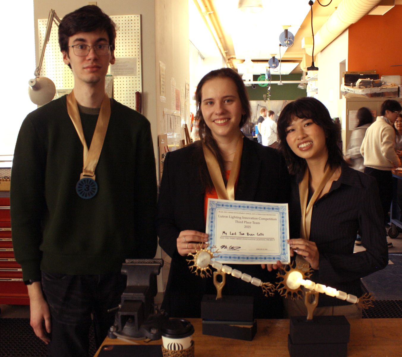 the 3 students who made the neuron project with their medals and their project