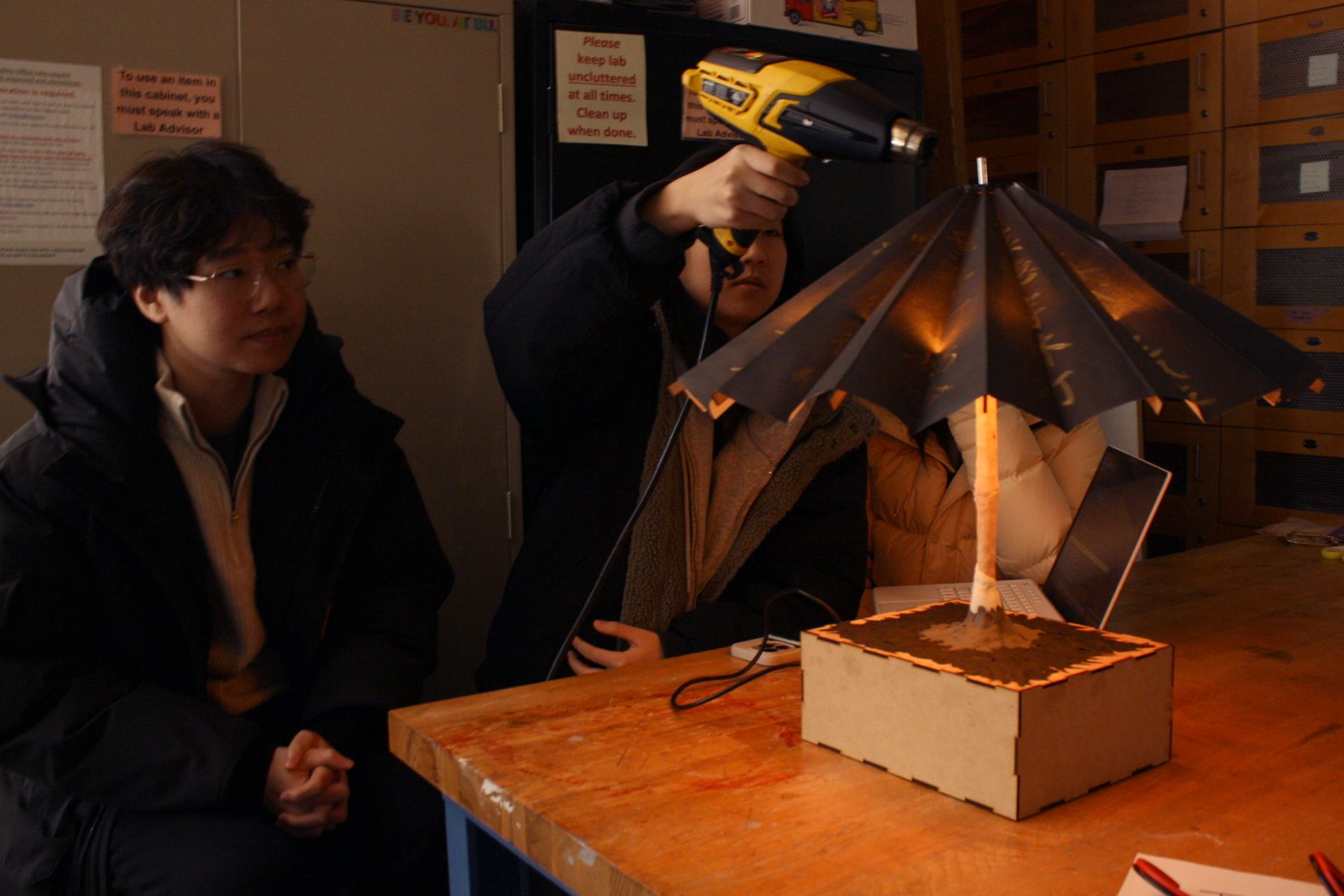 the umbrella team demonstrating the heat opening by aiming a heat gun at the tip of the umbrella