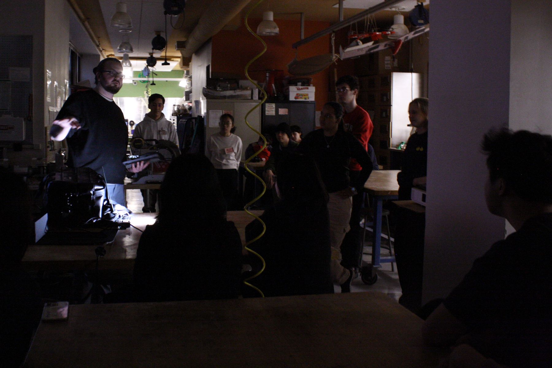 students across several tables in a dark room watching a Lutron lightbulb technology demo