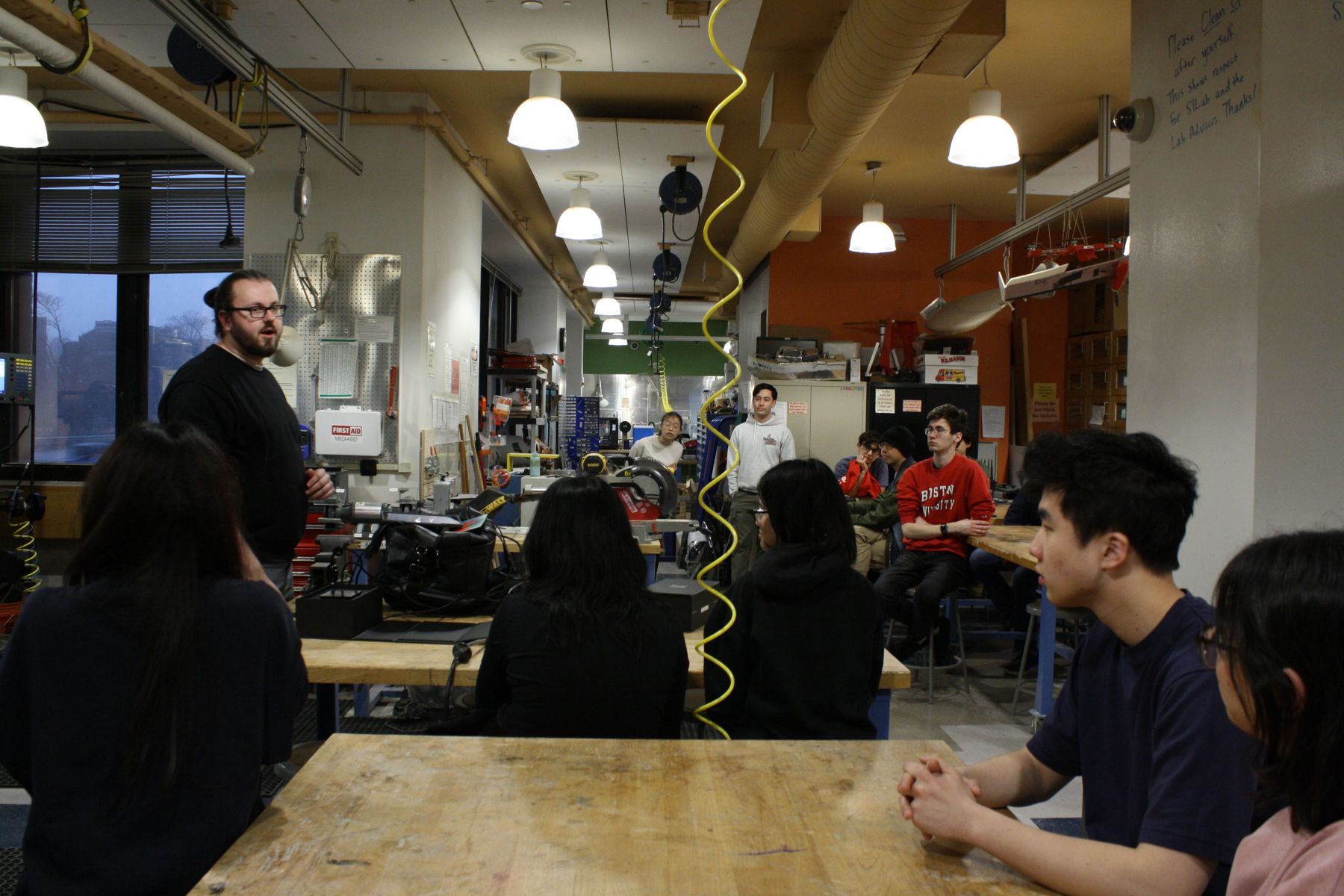 students across several tables watching a presentation from a Lutron Lighting rep