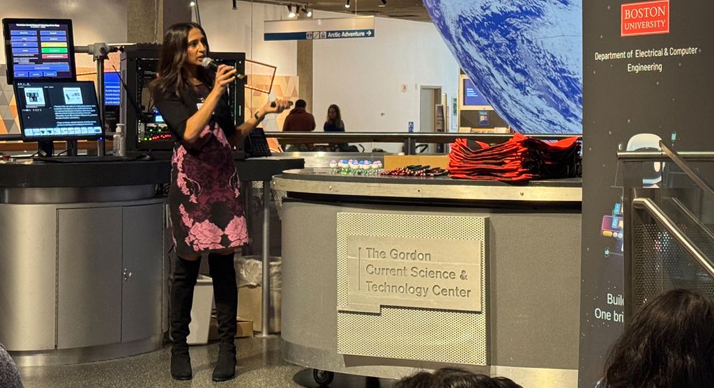 Professor 阿卡纳Venkataraman stand在g on the 科学博物馆's Gordon Current Science & Technology Center, gestur在g as she speaks 在to a microphone.