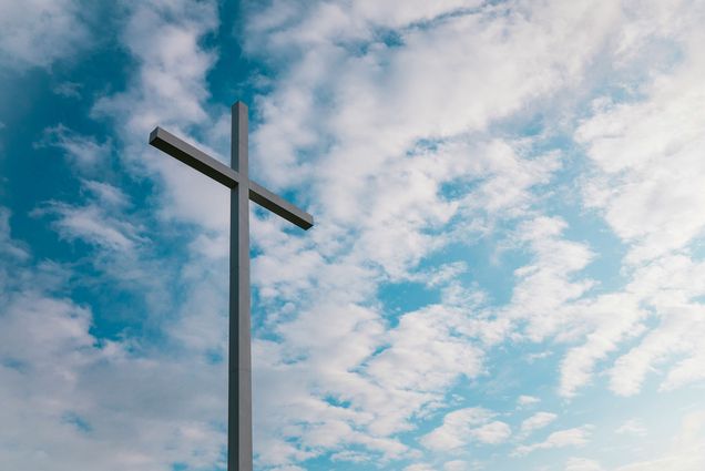 Photo: A cross in front of a blue sky background