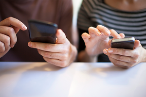 a man and woman using their smartphones