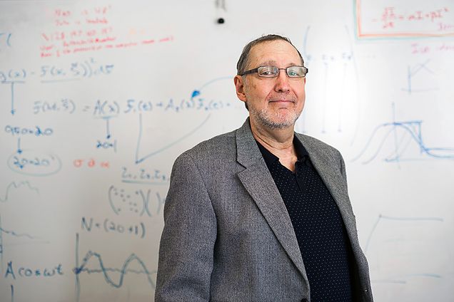 Kenneth Rothschild poses in front of whiteboard