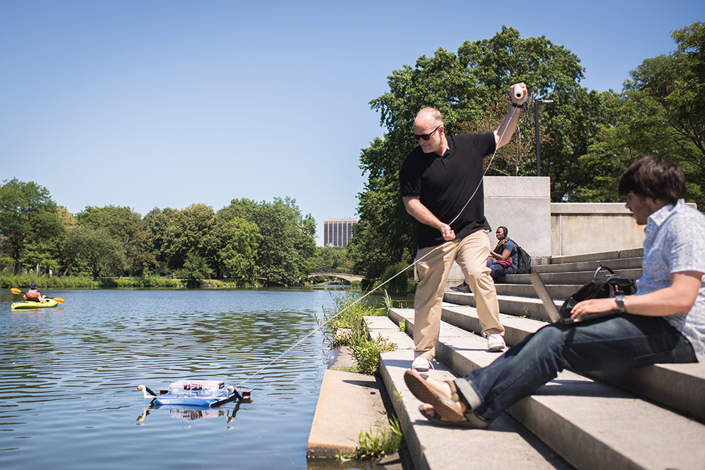 Greg McDaniel (left) pulls an autonomous robotic drone out of the Charles 
