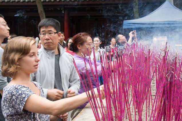 Clarinda lights bright pink incense in China.