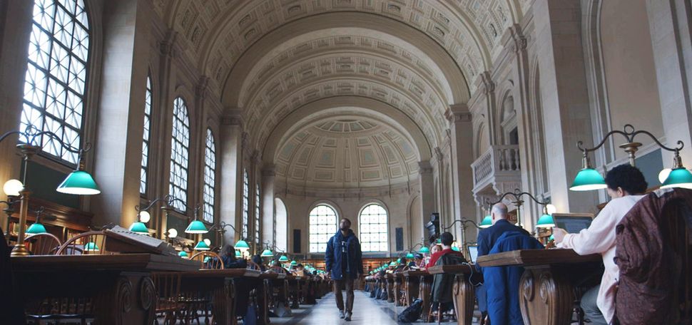 Charles Lewis walks through the Boston Public Library