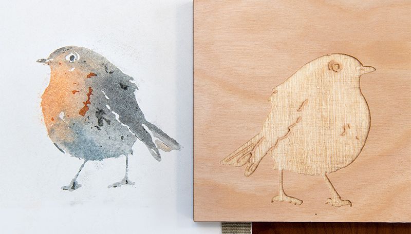 A detailed watercolor of a bird next to the laser-etched wood panel used to print the watercolor.