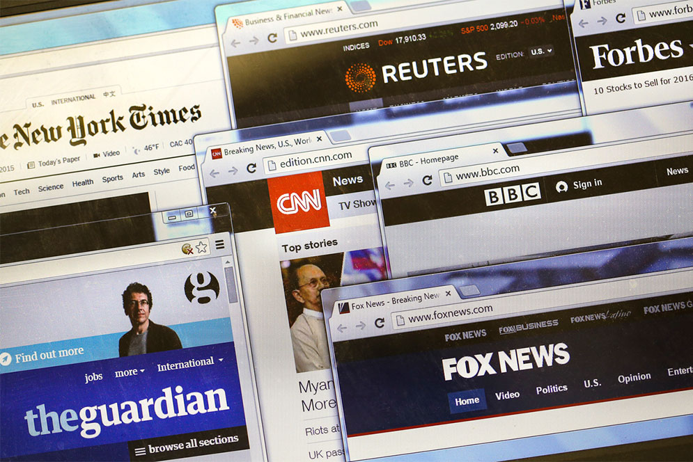 Composite image showing several open browswer windows displaying news websites such as New York Times, CNN, and The Guardian