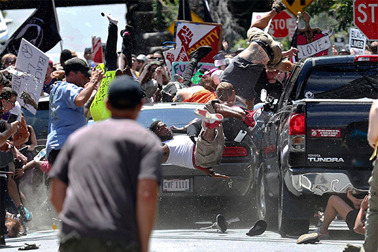 People fly into the air as a vehicle is driven into a group of protesters demonstrating against a white nationalist rally in Charlottesville, Va.