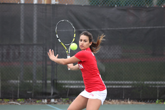 Remi Ramos swinging a racket at a tennis ball while on the court