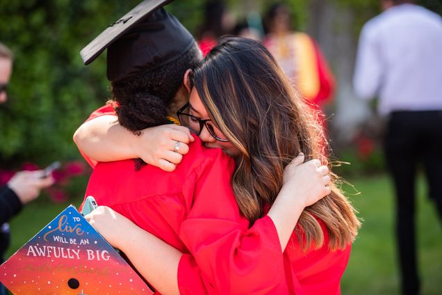 Two graduates embrace following commencement