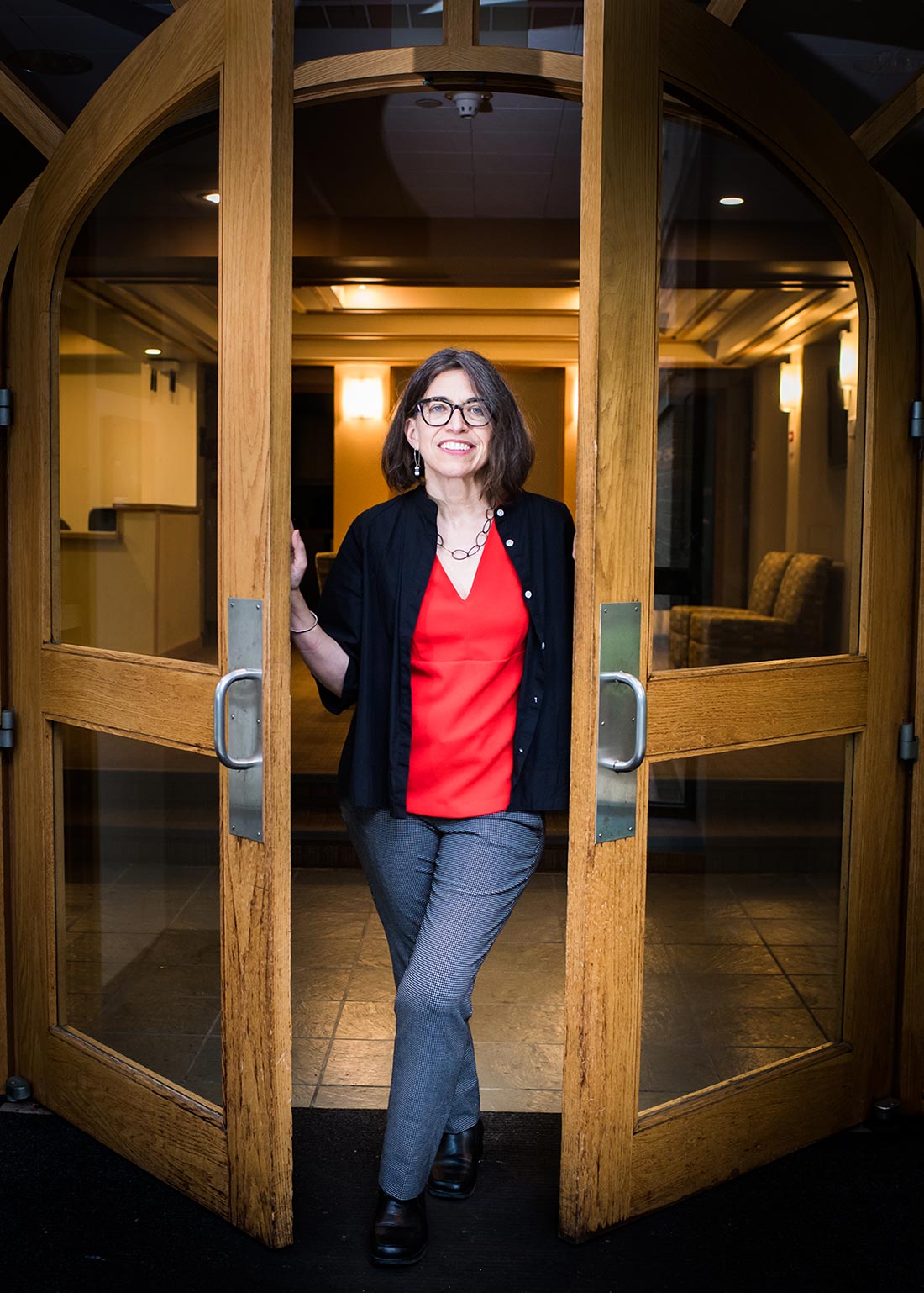 Portrait of Mary L. Churchill, former Vice President of Wheelock College, standing in a doorway.
