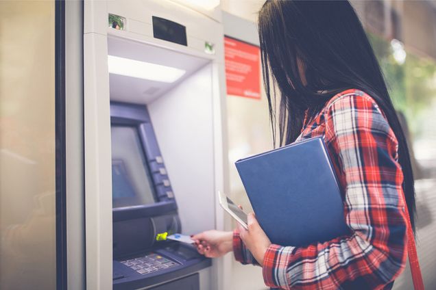 A woman withdraws cash from an ATM