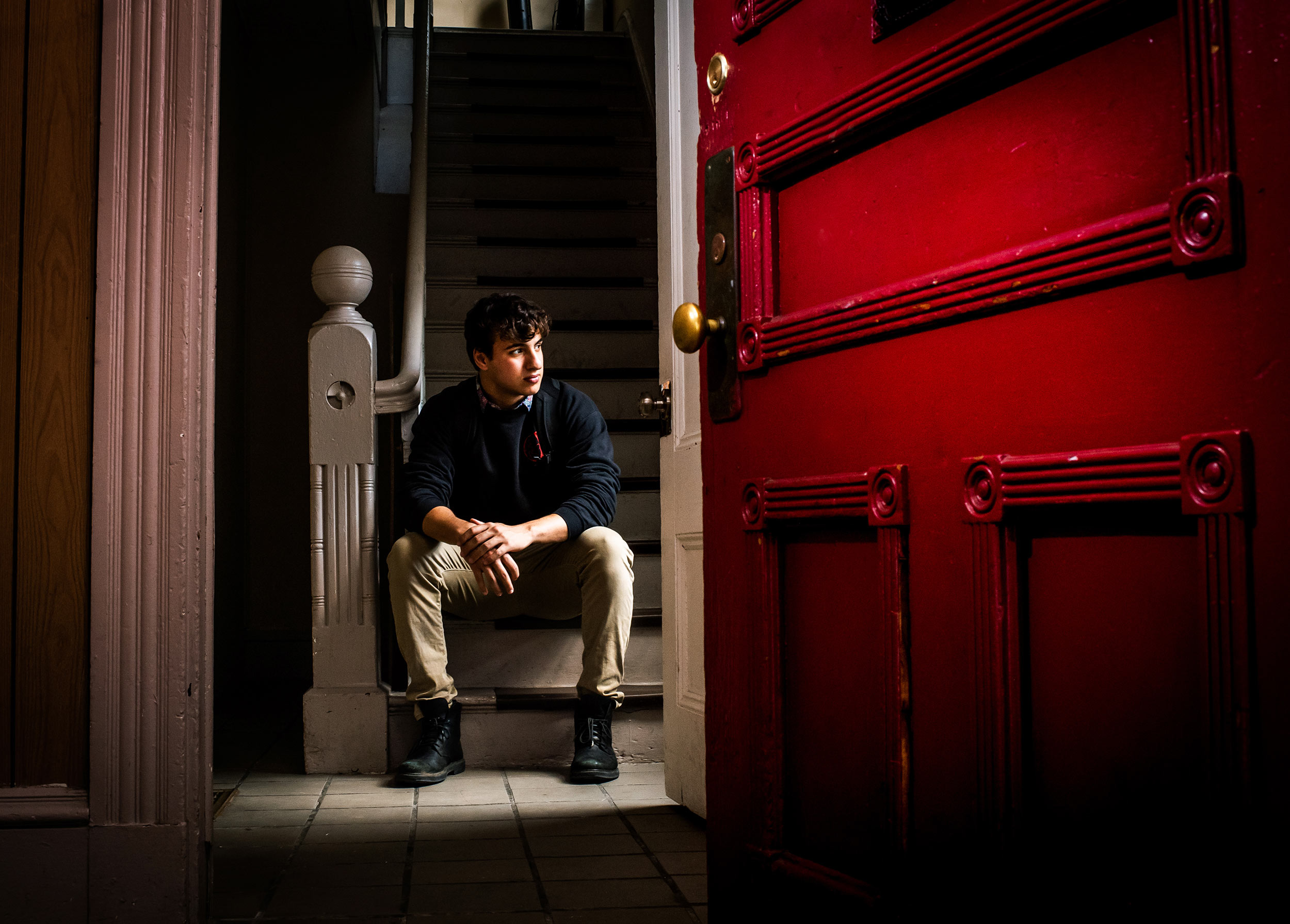 A Boston University student poses in the doorway of his new off-campus apartment in Allston.