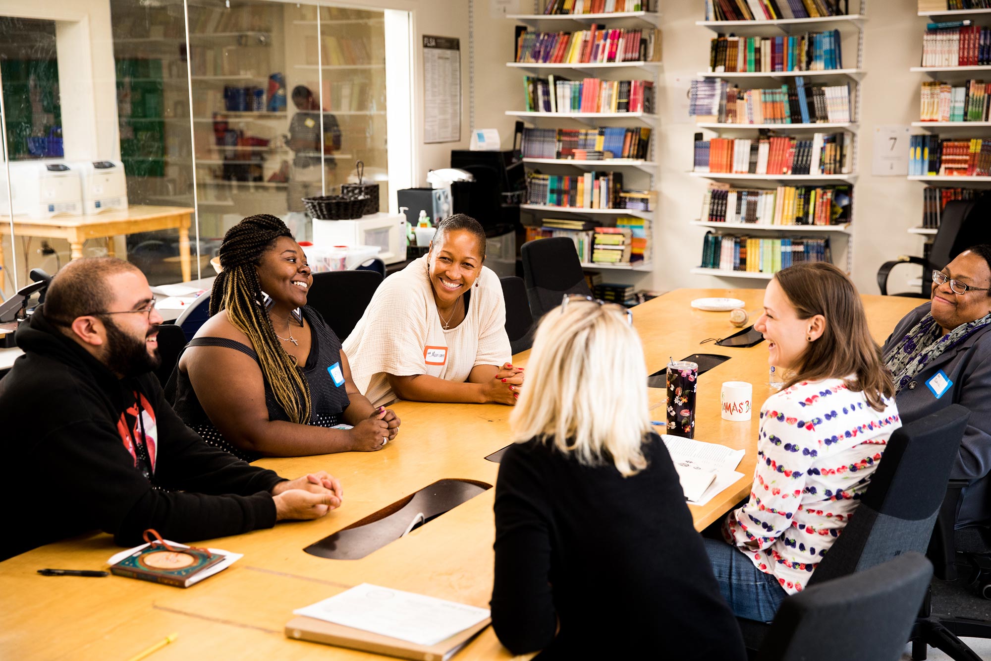 Members of a New Roots AME Church prayer group talk around a table.