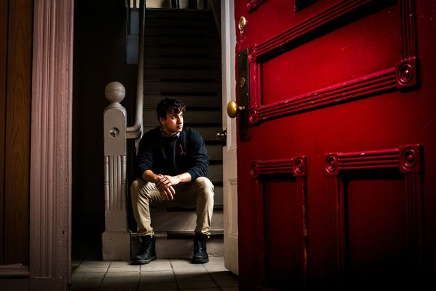 A Boston University student poses in the doorway of his new off-campus apartment in Allston.