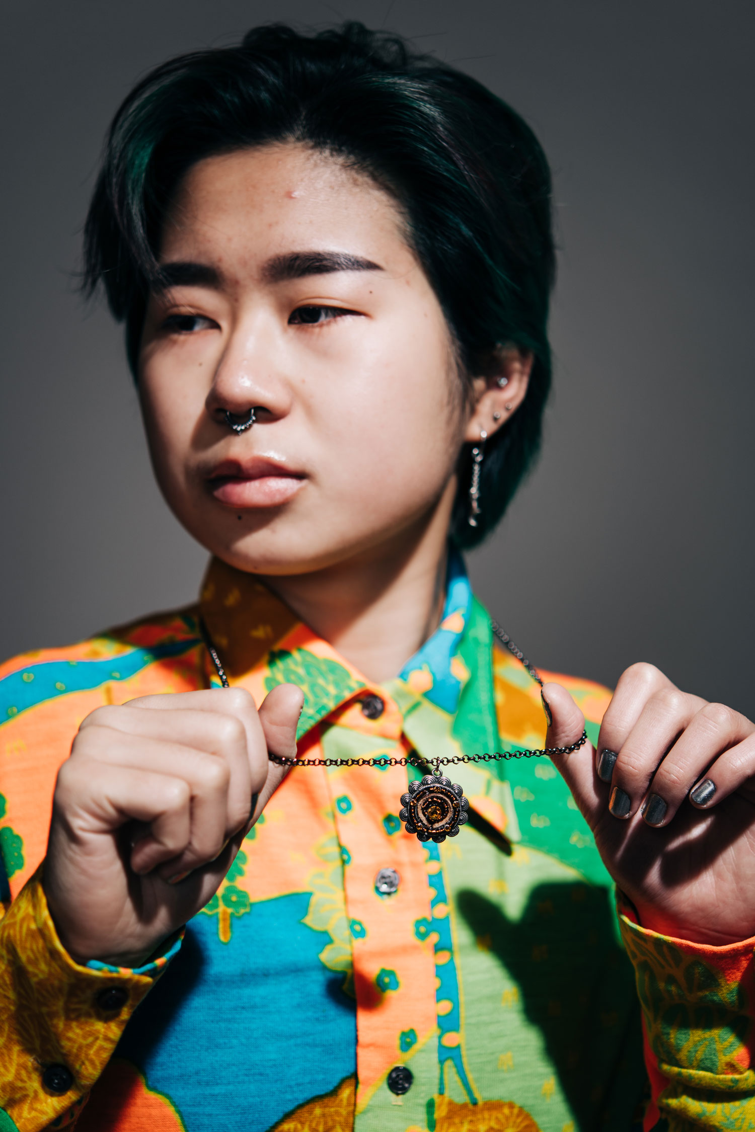 Alex Pan (Sargent’23) wearing a colorful thrifted shirt and a flower pendant necklace