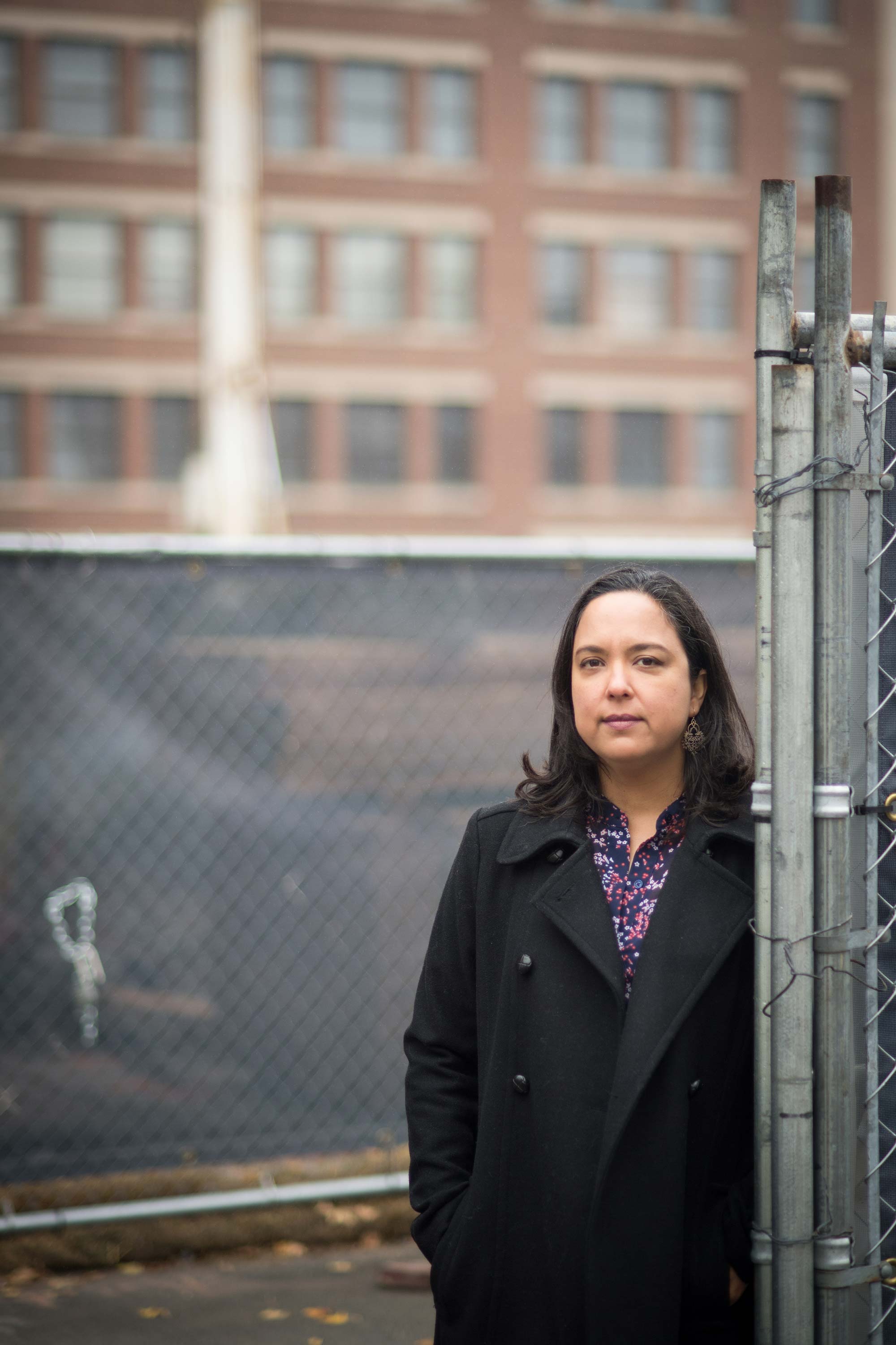 Portrait of Diana Ceballos, Boston University School of Public Health assistant professor of environmental health, in front of a Boston construction site.