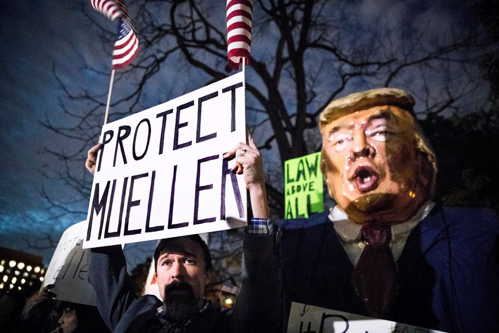 Someone holds a sign reading Protect Mueller during a protest