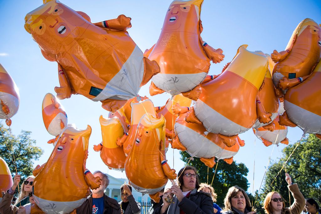 A group of protesters holds balloons depicting Trump as an orange baby