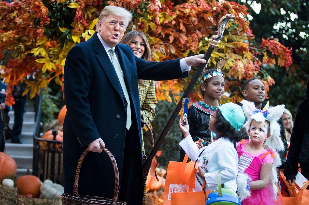 President Trump and First Lady Melania Trump handing out candy to trick or treaters at a White House event in 2018.