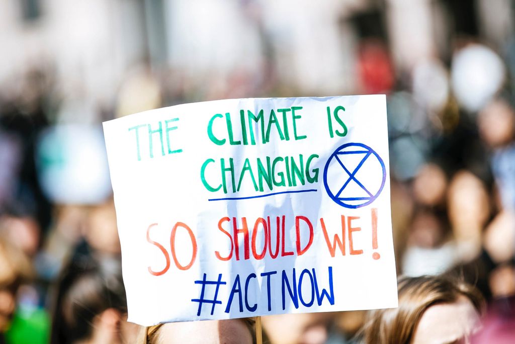 A photo of sign that reads "The Climate is Changing. So Should We! #ActNow"
