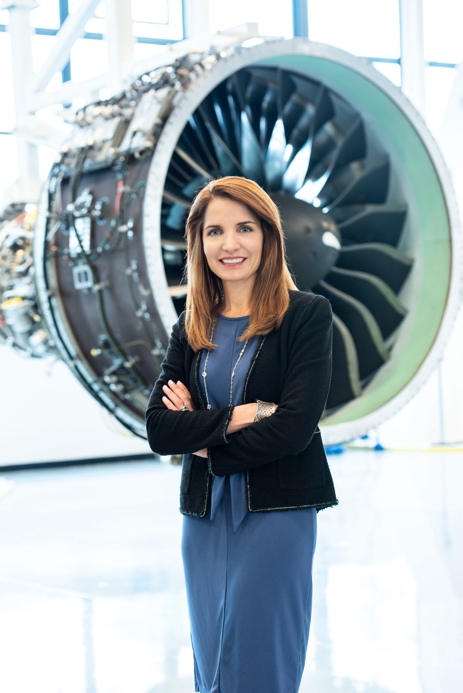 Jill Albertelli poses for a portrait in front of a jet engine.