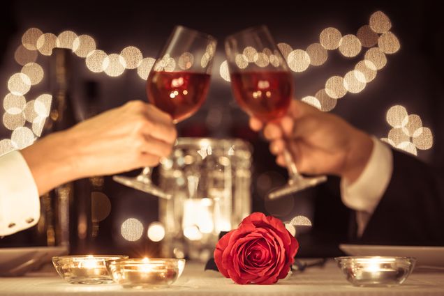 A photo of two people clinking wine glasses.