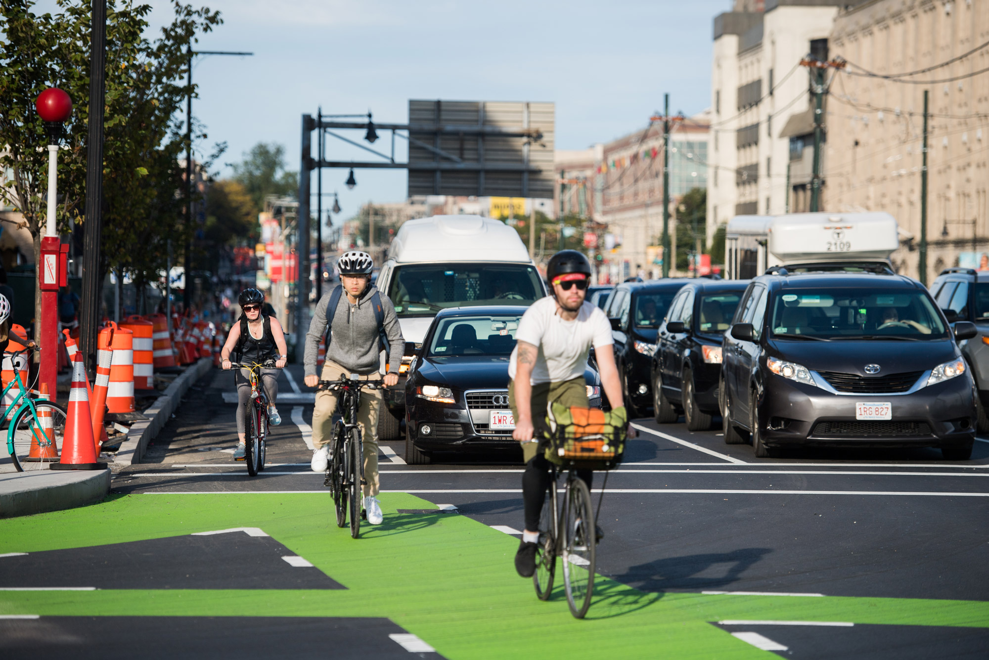Bicyclists and cars travel along comm ave