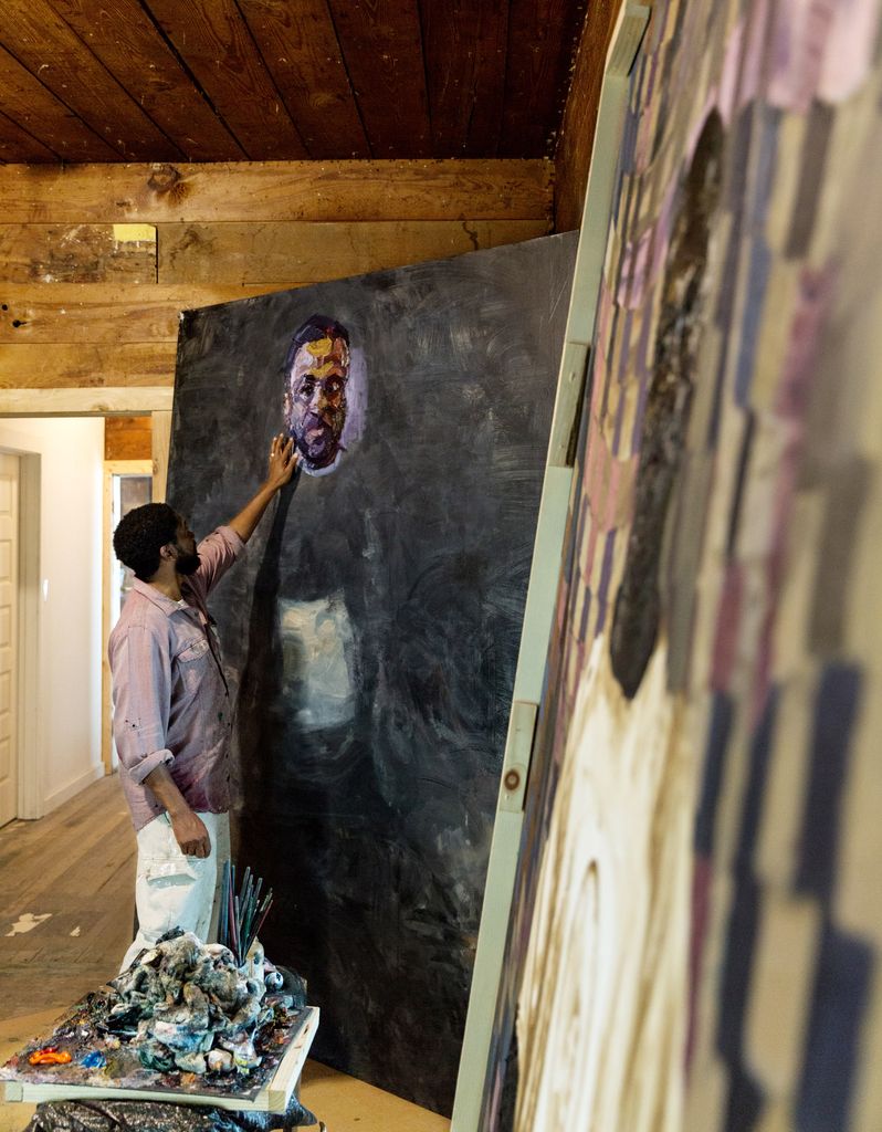 Sedrick Huckaby paints on a canvas taller than himself