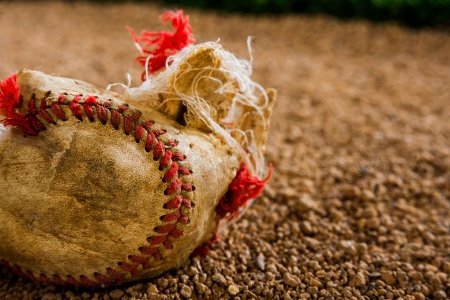 A destroyed baseball lays on the ground