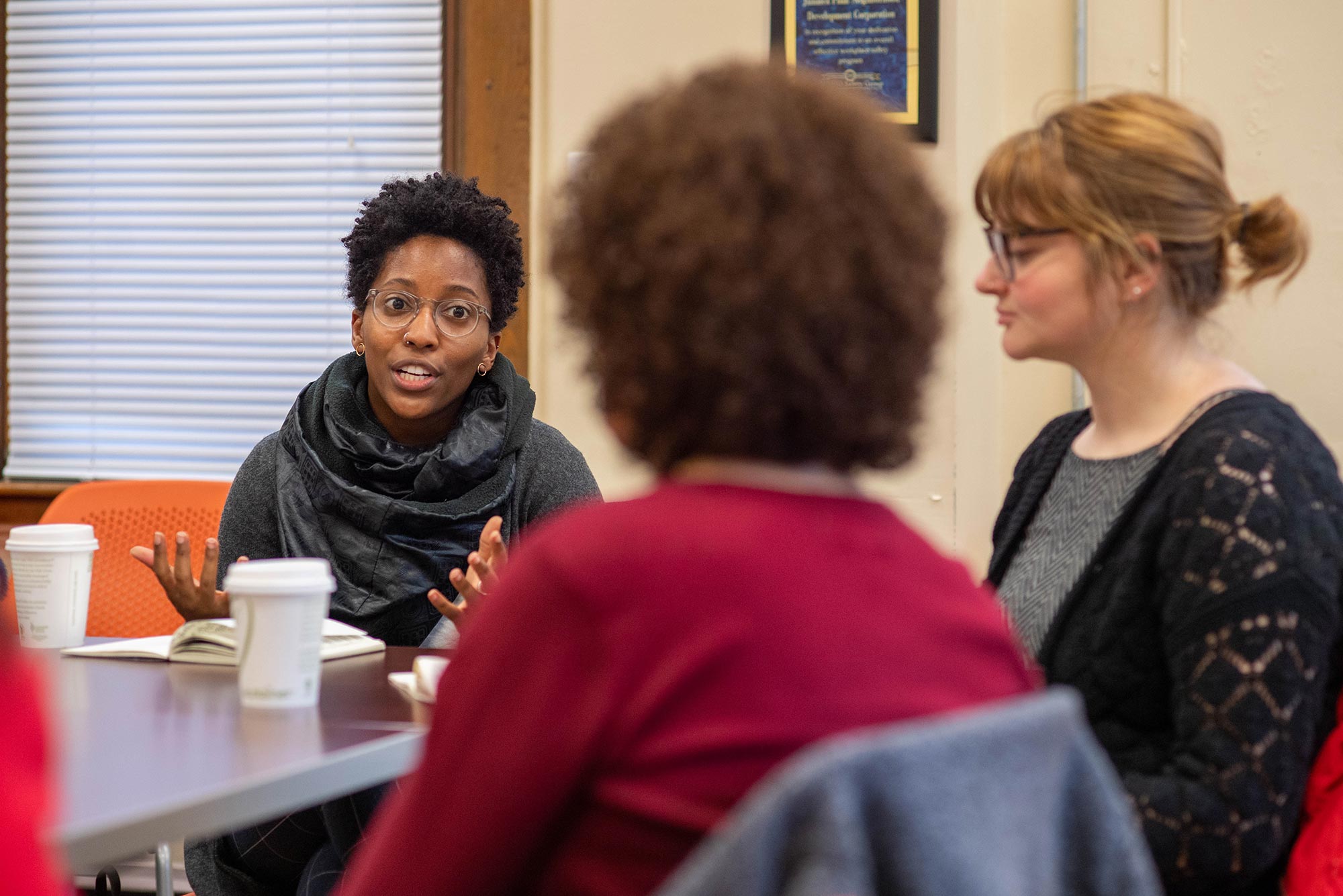 Taylor Cain (GRS’20), director of the Housing Innovation Lab, meets members of the Jamaica Plain Neighborhood Development Corp. Housing Innovation Lab intern Rebecca Christner pictured at right.