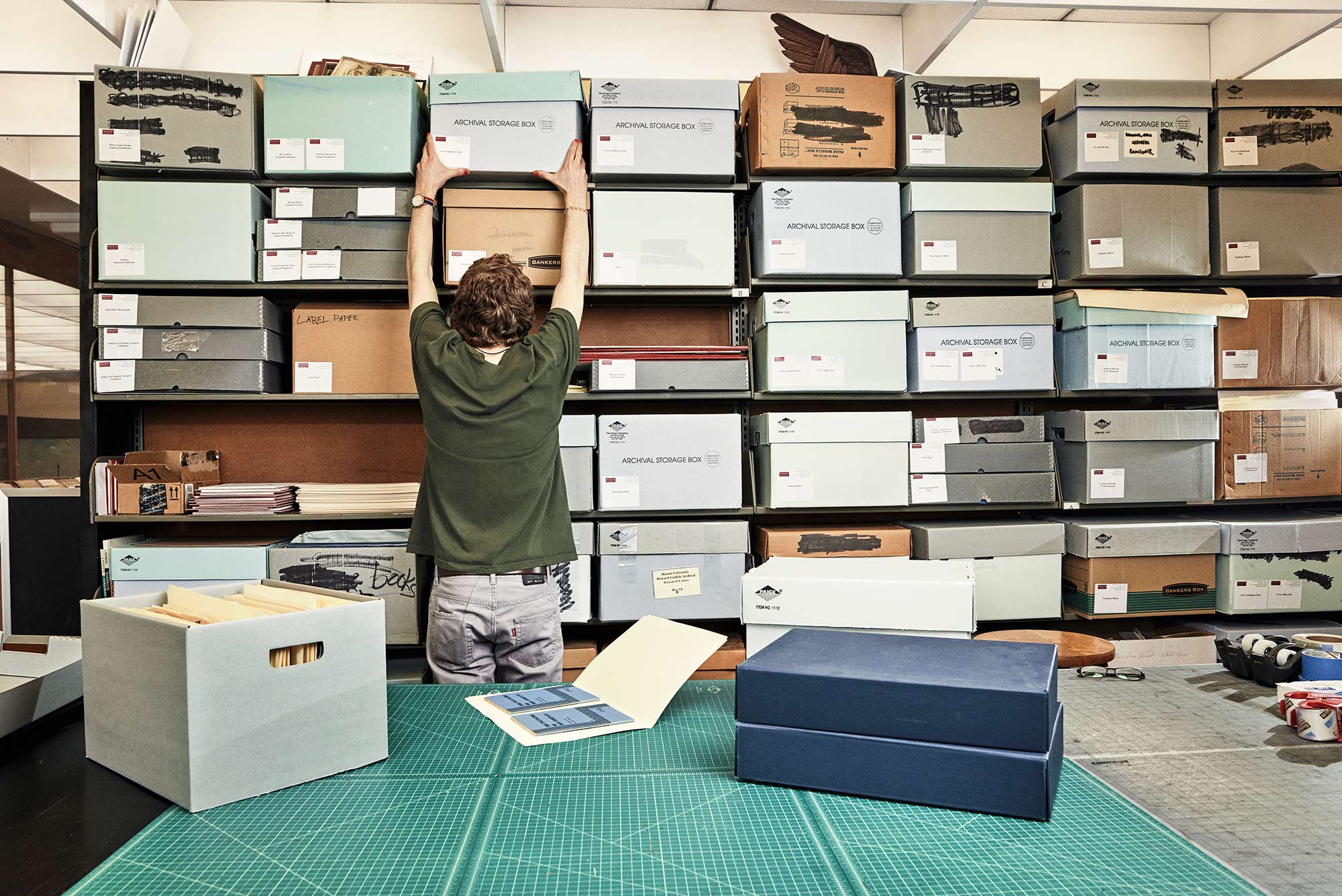 Photo of a student worker at the Howard Gotlieb Archival Research Center filing archive boxes.