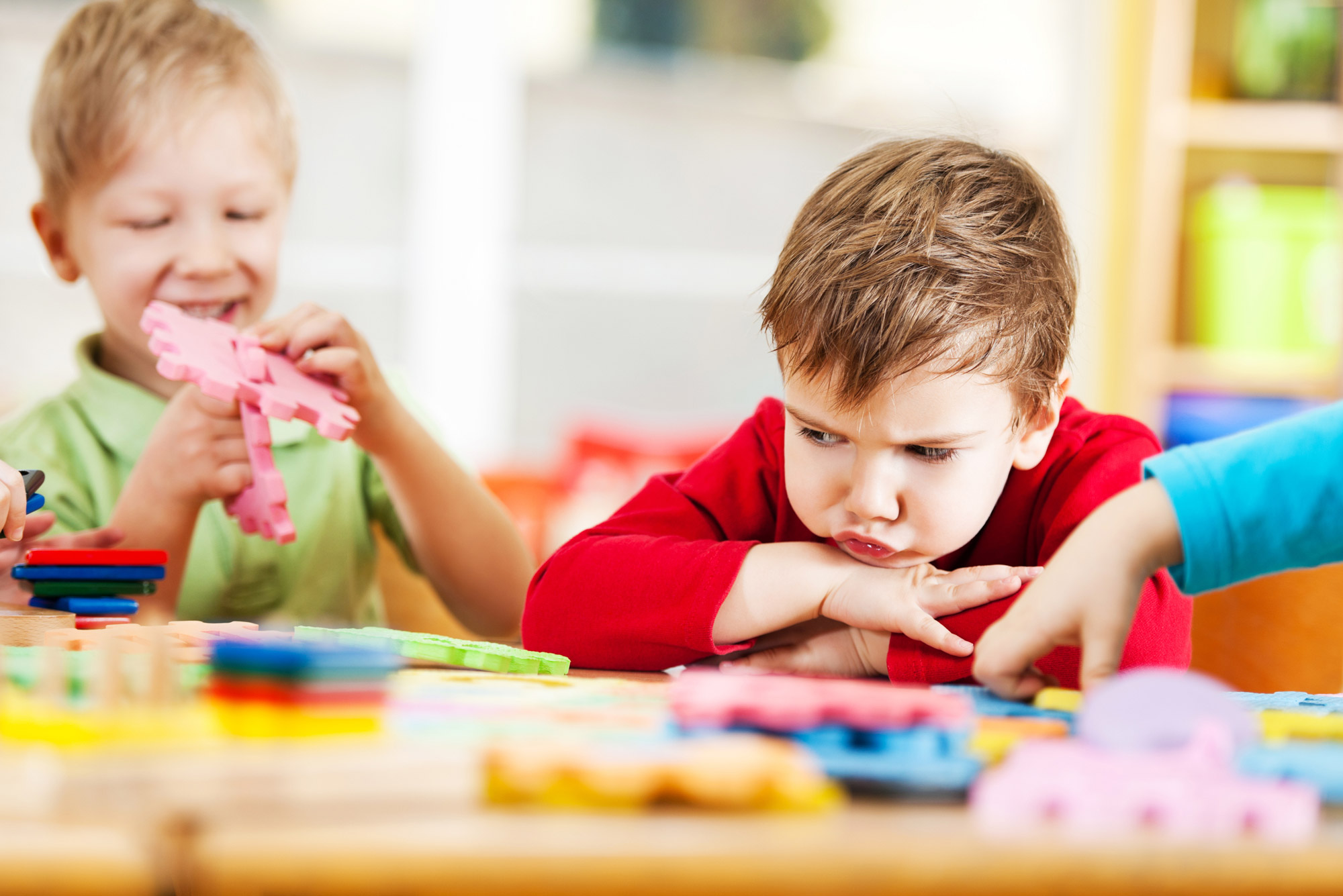 A photo of two children playing. One of them looks upset.