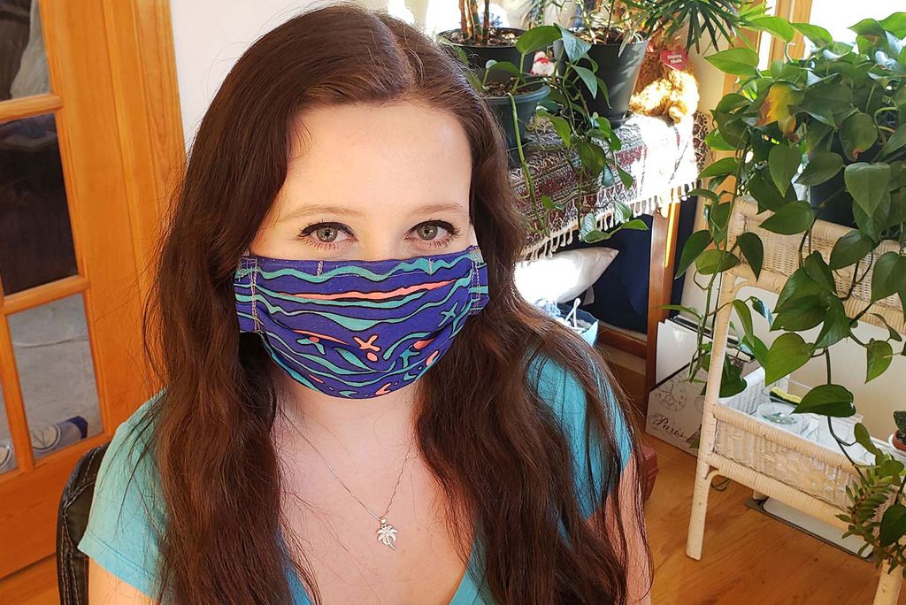 Image of Laura Stursberg with a dark blue, hand-sewn face mask on in her home in Connecticut.