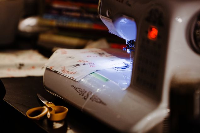 Image of a sewing machine with the light and a piece of BU-patterned fabric underneath the needle.