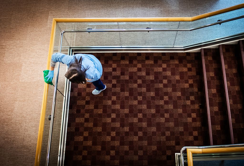 Overhead photo of a BU custodial worker cleaning railings.