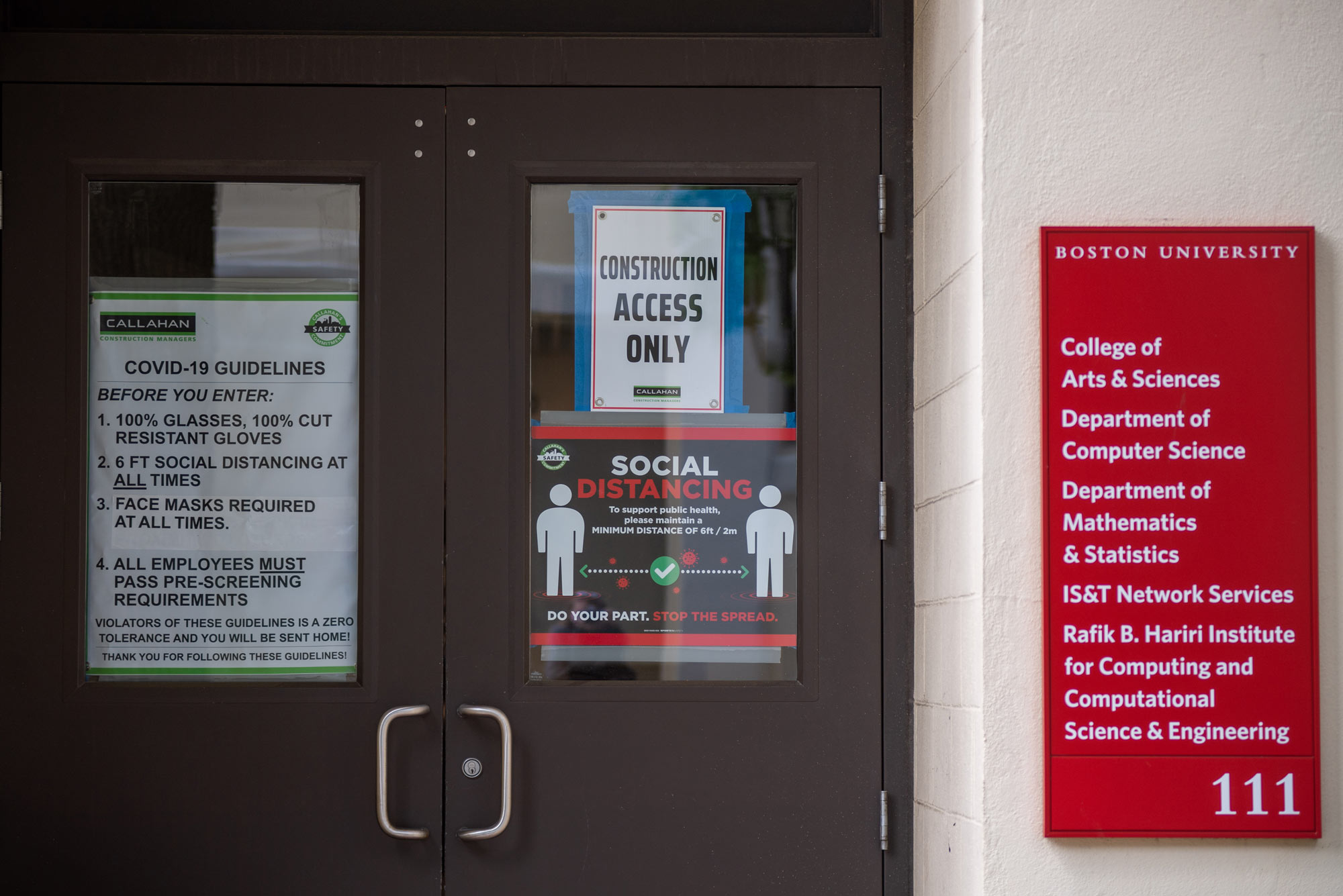A photo of the entryway of 111 Commonwealth Ave. with signs on COVID-19 safety protocols